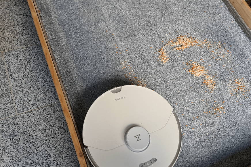 Roborock S7 Pro Ultra vacuum robot cleans oatmeal on a high pile carpet.